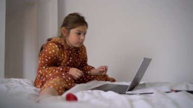 Genç kız evde bilgisayarla internette öğrenim görüyor..