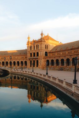 Günbatımında, Seville 'deki Majestic Plaza de Espana kanalı yansıtıyor..