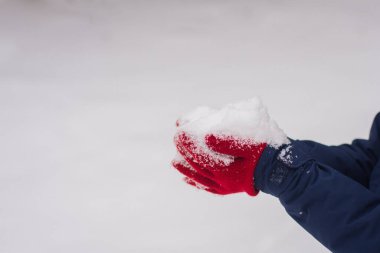 Uçan kar taneleri. Ellere kar. Karlı kırmızı eldivenler. Mutlu kış zamanları.