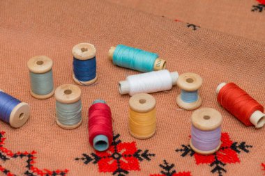 Coil thread on the canvas. Multicolored thread. Wooden coils.
