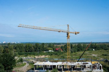 Günbatımı arka planında vinç siluetleri olan sanayi manzarası