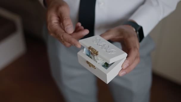 一个男人手里拿着一个漂亮的木盒 手里拿着结婚戒指 结婚戒指在一个漂亮的盒子里 — 图库视频影像