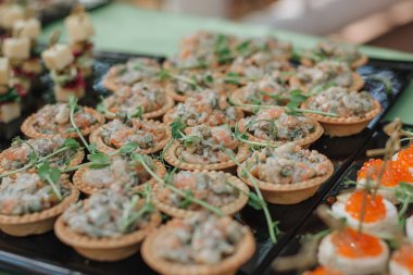 Parmak yiyeceği. Şişte peynir ve domates dilimleri. İtalyan aperatifleri peynirli, kiraz domatesli ve zeytinli siyah tahtada çubuklar, yemek servisi, ziyafet.