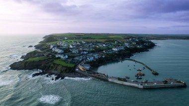 Ballycotton köyünün çarpıcı hava manzarası, engebeli uçurumları, dingin limanı ve deniz feneriyle