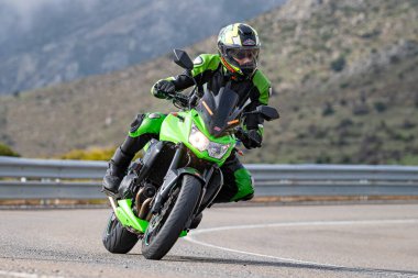 Motosikletli keskin bir viraj alıyor. Fotoğraf 9 Eylül 2022 tarihinde İspanya 'nın Avila ilinin Navalmoral limanında çekildi.