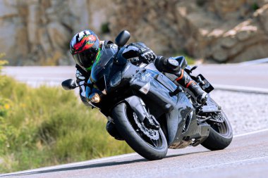 Motosikletli keskin bir viraj alıyor. Fotoğraf 9 Eylül 2022 tarihinde İspanya 'nın Avila ilinin Navalmoral limanında çekildi.