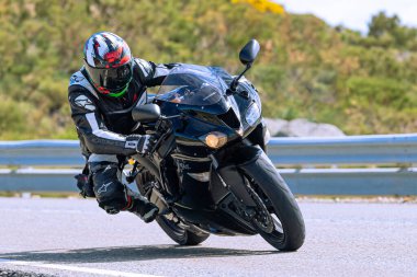 Motosikletli keskin bir viraj alıyor. Fotoğraf 9 Eylül 2022 tarihinde İspanya 'nın Avila ilinin Navalmoral limanında çekildi.