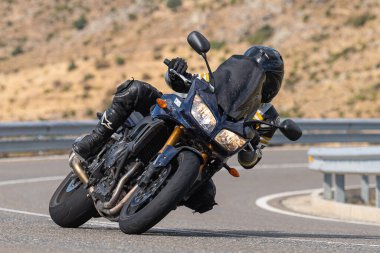 Motosikletli keskin bir viraj alıyor. Fotoğraf 9 Eylül 2022 tarihinde İspanya 'nın Avila ilinin Navalmoral limanında çekildi.