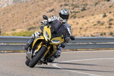 Motosikletli keskin bir viraj alıyor. Fotoğraf 9 Eylül 2022 tarihinde İspanya 'nın Avila ilinin Navalmoral limanında çekildi.