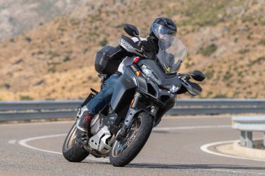 Motosikletli keskin bir viraj alıyor. Fotoğraf 9 Eylül 2022 tarihinde İspanya 'nın Avila ilinin Navalmoral limanında çekildi.