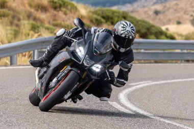 Motosikletli keskin bir viraj alıyor. Fotoğraf 9 Eylül 2022 tarihinde İspanya 'nın Avila ilinin Navalmoral limanında çekildi.