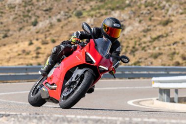 Motosikletli keskin bir viraj alıyor. Fotoğraf 9 Eylül 2022 tarihinde İspanya 'nın Avila ilinin Navalmoral limanında çekildi.