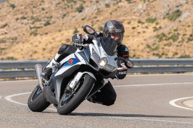 Motosikletli keskin bir viraj alıyor. Fotoğraf 9 Eylül 2020 tarihinde İspanya 'nın Avila ilinin Navalmoral limanında çekildi.