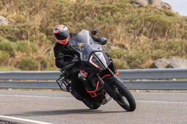 Motosikletli keskin bir viraj alıyor. Fotoğraf 9 Eylül 2020 tarihinde İspanya 'nın Avila ilinin Navalmoral limanında çekildi.