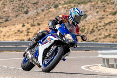 Motosikletli keskin bir viraj alıyor. Fotoğraf 9 Eylül 2020 tarihinde İspanya 'nın Avila ilinin Navalmoral limanında çekildi.