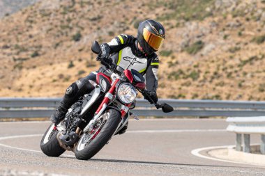Motosikletli keskin bir viraj alıyor. Fotoğraf 9 Eylül 2020 tarihinde İspanya 'nın Avila ilinin Navalmoral limanında çekildi.