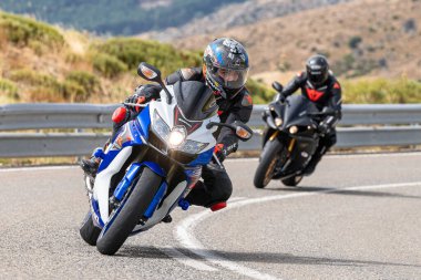 Motosikletli keskin bir viraj alıyor. Fotoğraf 9 Eylül 2020 tarihinde İspanya 'nın Avila ilinin Navalmoral limanında çekildi.