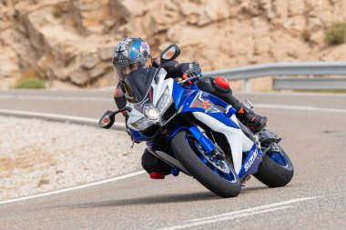 Motosikletli keskin bir viraj alıyor. Fotoğraf 9 Eylül 2020 tarihinde İspanya 'nın Avila ilinin Navalmoral limanında çekildi.