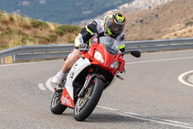 Motosikletli keskin bir viraj alıyor. Fotoğraf 9 Eylül 2020 tarihinde İspanya 'nın Avila ilinin Navalmoral limanında çekildi.
