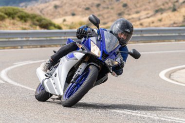 Motosikletli keskin bir viraj alıyor. Fotoğraf 9 Eylül 2020 tarihinde İspanya 'nın Avila ilinin Navalmoral limanında çekildi.