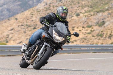 Motosikletli keskin bir viraj alıyor. Fotoğraf 9 Eylül 2020 tarihinde İspanya 'nın Avila ilinin Navalmoral limanında çekildi.
