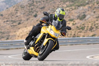 Motosikletli keskin bir viraj alıyor. Fotoğraf 9 Eylül 2020 tarihinde İspanya 'nın Avila ilinin Navalmoral limanında çekildi.