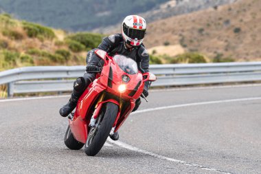 Motosikletli keskin bir viraj alıyor. Fotoğraf 9 Eylül 2020 tarihinde İspanya 'nın Avila ilinin Navalmoral limanında çekildi.