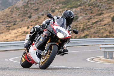 Motosikletli keskin bir viraj alıyor. Fotoğraf 9 Eylül 2020 tarihinde İspanya 'nın Avila ilinin Navalmoral limanında çekildi.