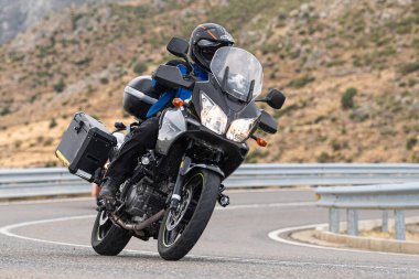 Motosikletli keskin bir viraj alıyor. Fotoğraf 9 Eylül 2020 tarihinde İspanya 'nın Avila ilinin Navalmoral limanında çekildi.