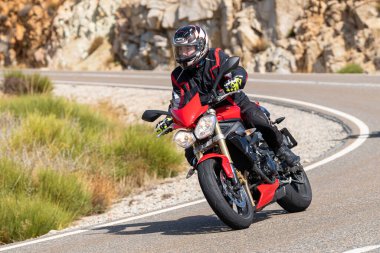 Motosikletli keskin bir viraj alıyor. Fotoğraf 9 Eylül 2020 tarihinde İspanya 'nın Avila ilinin Navalmoral limanında çekildi.