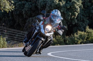 Motosikletli keskin bir viraj alıyor. Fotoğraf 9 Eylül 2020 tarihinde İspanya 'nın Avila ilinin Navalmoral limanında çekildi.