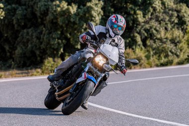 Motosikletli keskin bir viraj alıyor. Fotoğraf 9 Eylül 2020 tarihinde İspanya 'nın Avila ilinin Navalmoral limanında çekildi.