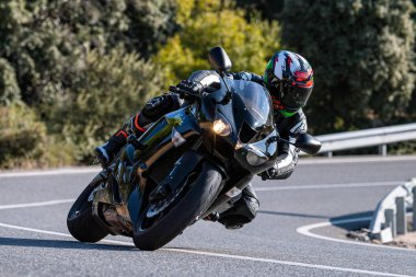 Motosikletli keskin bir viraj alıyor. Fotoğraf 9 Eylül 2020 tarihinde İspanya 'nın Avila ilinin Navalmoral limanında çekildi.