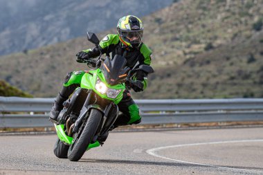 Motosikletli keskin bir viraj alıyor. Fotoğraf 9 Eylül 2020 tarihinde İspanya 'nın Avila ilinin Navalmoral limanında çekildi.