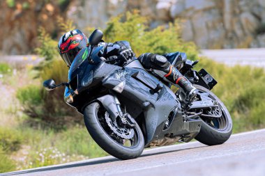 Motosikletli keskin bir viraj alıyor. Fotoğraf 9 Eylül 2020 tarihinde İspanya 'nın Avila ilinin Navalmoral limanında çekildi.