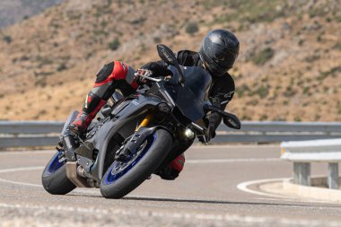 Motosikletli keskin bir viraj alıyor. Fotoğraf 9 Eylül 2020 tarihinde İspanya 'nın Avila ilinin Navalmoral limanında çekildi.