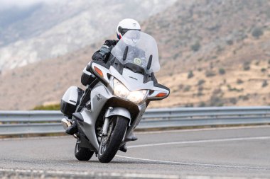 Motosikletli keskin bir viraj alıyor. Fotoğraf 9 Eylül 2020 tarihinde İspanya 'nın Avila ilinin Navalmoral limanında çekildi.