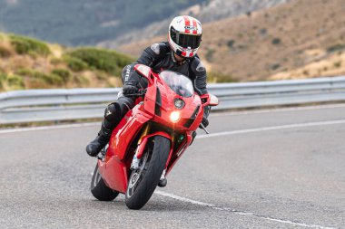 Motosikletli keskin bir viraj alıyor. Fotoğraf 9 Eylül 2020 tarihinde İspanya 'nın Avila ilinin Navalmoral limanında çekildi.