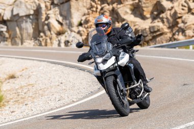 Motosikletli keskin bir viraj alıyor. Fotoğraf 9 Eylül 2020 tarihinde İspanya 'nın Avila ilinin Navalmoral limanında çekildi.