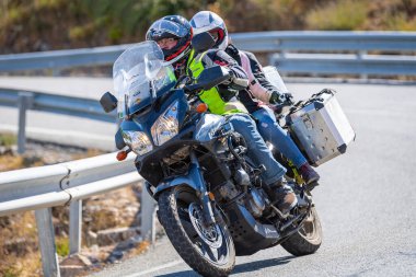 motorcyclist taking a sharp curve on his bike. Photograph taken in the port of Navalmoral, province of the city of Avila, Spain, during the day September 10, 2022