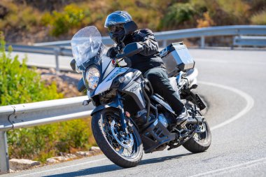 motorcyclist taking a sharp curve on his bike. Photograph taken in the port of Navalmoral, province of the city of Avila, Spain, during the day September 10, 2022