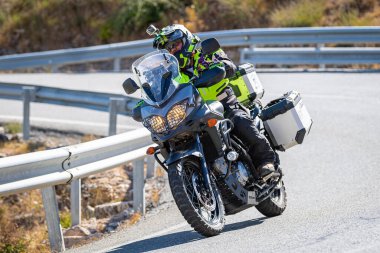 Motosikletli keskin bir viraj alıyor. Fotoğraf 9 Eylül 2020 tarihinde İspanya 'nın Avila ilinin Navalmoral limanında çekildi.