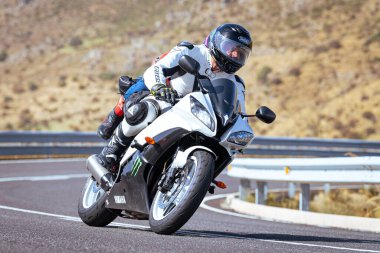 Motosikletli keskin bir viraj alıyor. Fotoğraf 9 Eylül 2020 tarihinde İspanya 'nın Avila ilinin Navalmoral limanında çekildi.