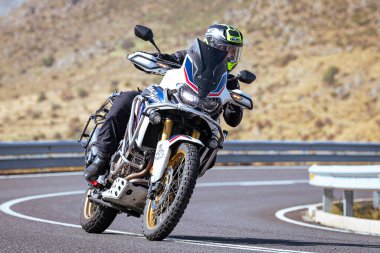 Motosikletli keskin bir viraj alıyor. Fotoğraf 9 Eylül 2020 tarihinde İspanya 'nın Avila ilinin Navalmoral limanında çekildi.