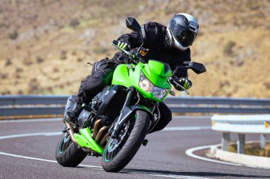 Motosikletli keskin bir viraj alıyor. Fotoğraf 9 Eylül 2020 tarihinde İspanya 'nın Avila ilinin Navalmoral limanında çekildi.