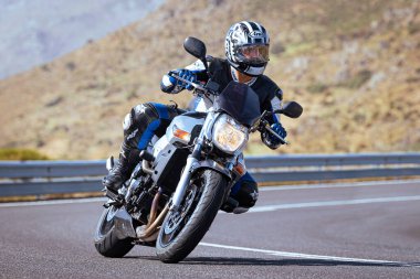 Motosikletli keskin bir viraj alıyor. Fotoğraf 9 Eylül 2020 tarihinde İspanya 'nın Avila ilinin Navalmoral limanında çekildi.