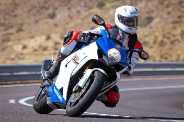 Motosikletli keskin bir viraj alıyor. Fotoğraf 9 Eylül 2020 tarihinde İspanya 'nın Avila ilinin Navalmoral limanında çekildi.