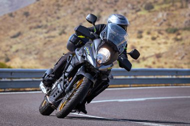 Motosikletli keskin bir viraj alıyor. Fotoğraf 9 Eylül 2020 tarihinde İspanya 'nın Avila ilinin Navalmoral limanında çekildi.