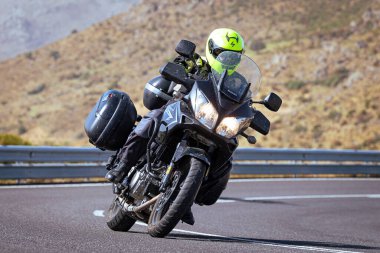 Motosikletli keskin bir viraj alıyor. Fotoğraf 9 Eylül 2020 tarihinde İspanya 'nın Avila ilinin Navalmoral limanında çekildi.