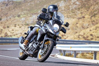 Motosikletli keskin bir viraj alıyor. Fotoğraf 9 Eylül 2020 tarihinde İspanya 'nın Avila ilinin Navalmoral limanında çekildi.